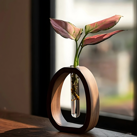 Vase mit Holzrahmen und Glaskolben am Fenster mit Zweig
